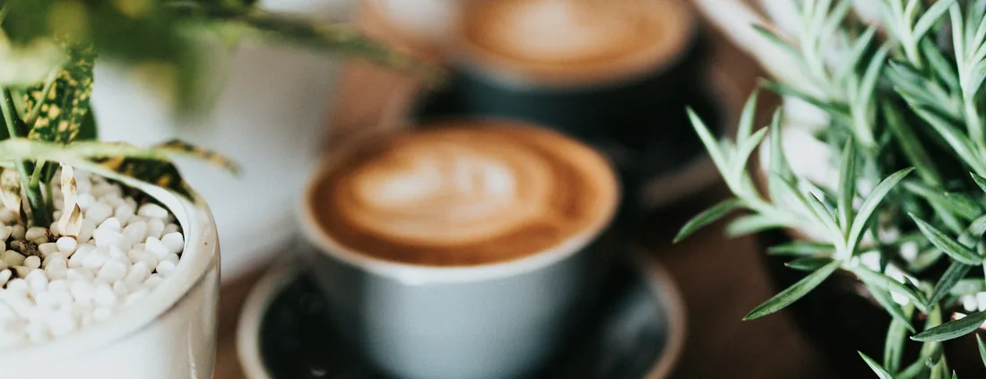Cappuccino mit Latte Art in dunkler Tasse